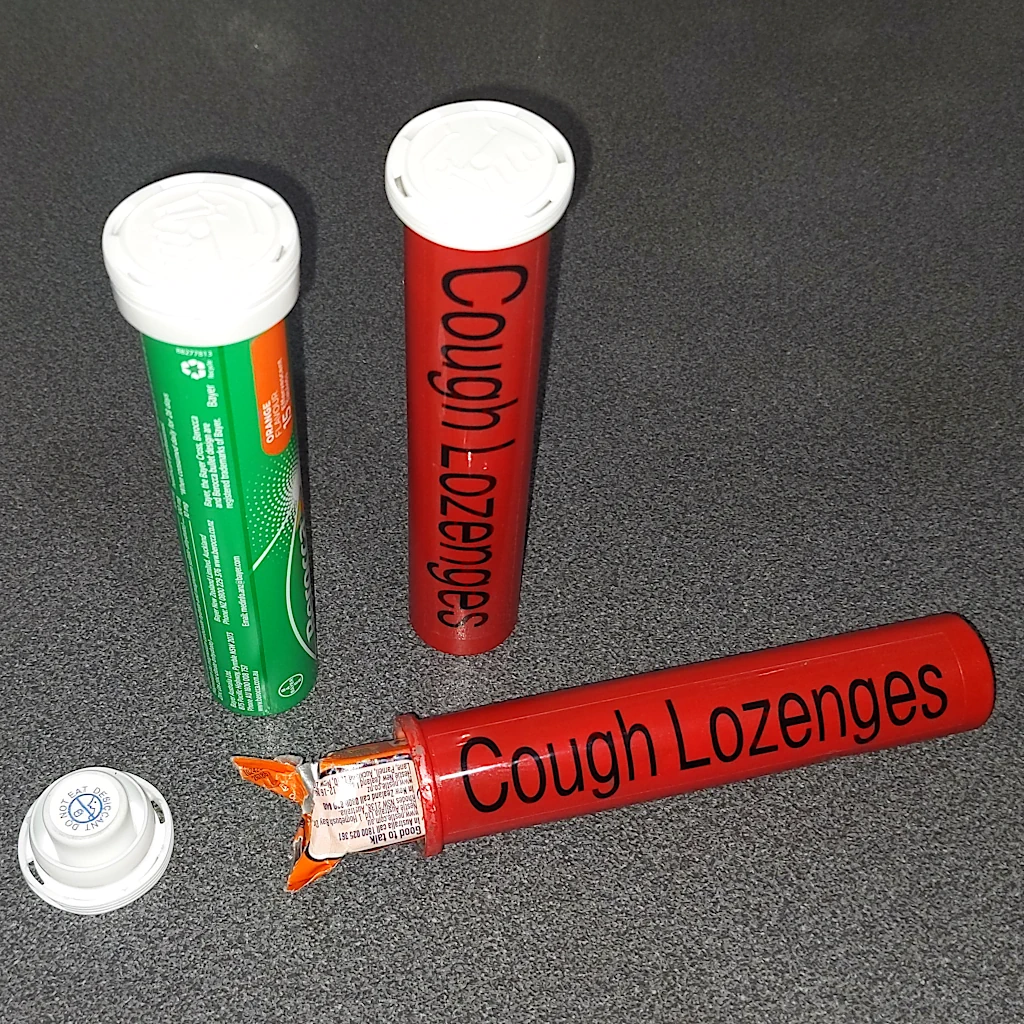 Vitamin capsules into cough lozenge containers.